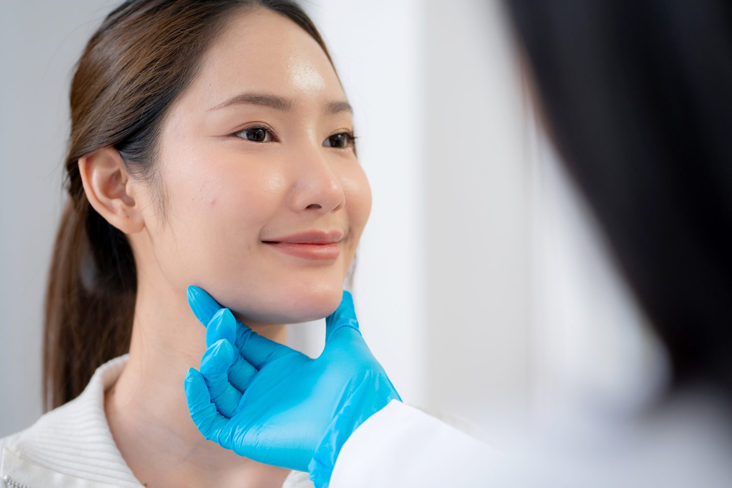 Doctor assessing a patient's facial skin during a consultation
