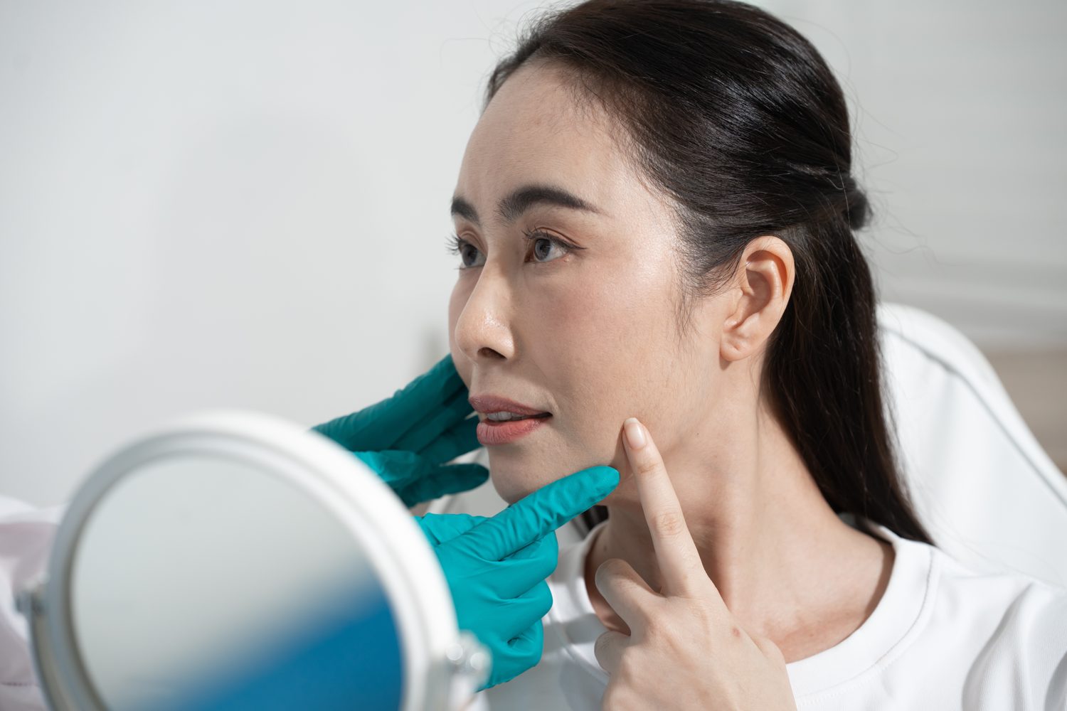 Doctor assessing a patient's facial skin before laser treatment