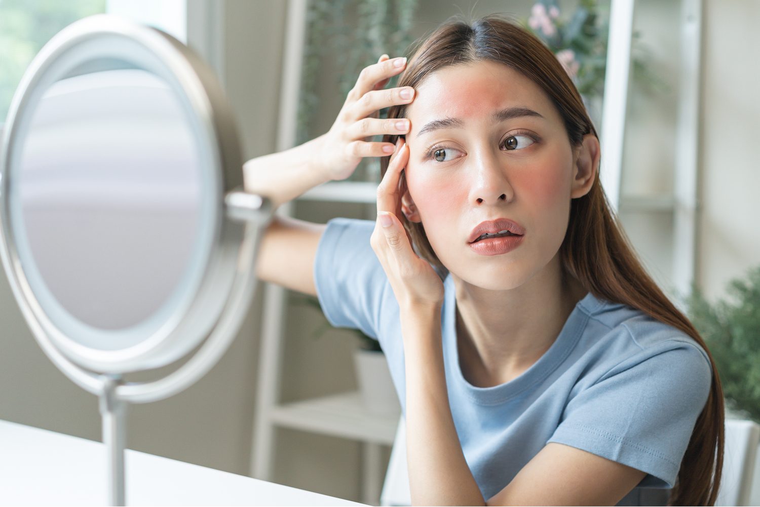 Woman checking facial redness in a mirror after treatment