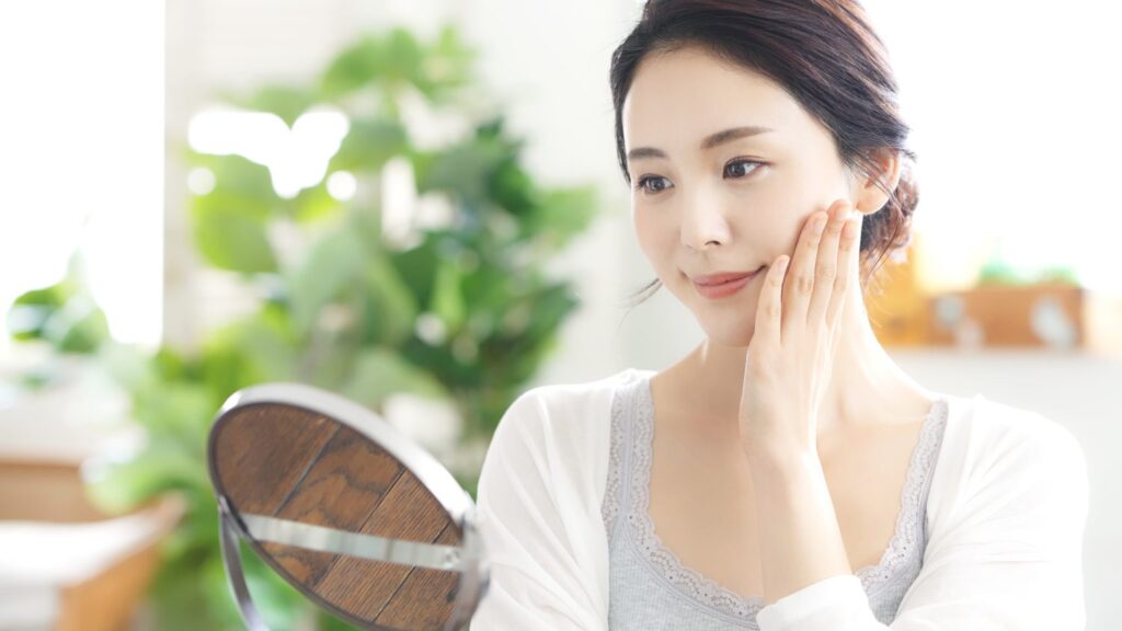 Woman checking firm skin on her cheek in a mirror